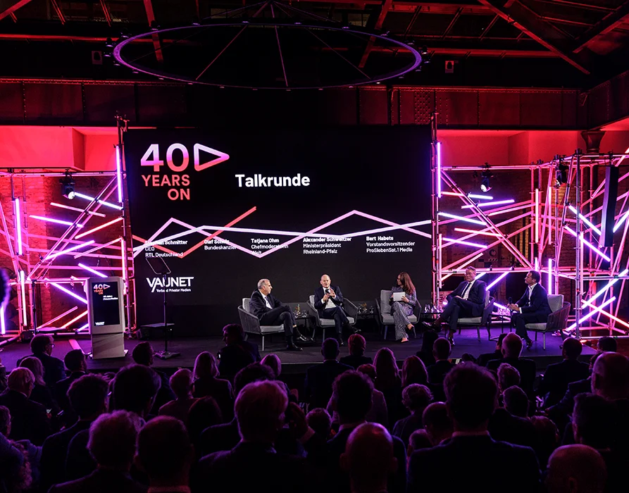 Fernsehstudio mit 5 Personen auf der Bühne in einer Talkrunde zum Thema "40 years on" – 40 Jahre Privatfernsehen. Im Vordergrund ist das Publikum sichtbar. (Foto)